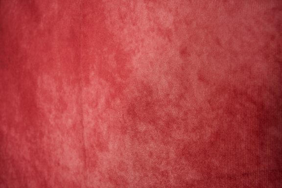 Rote, samtartige Textur mit leicht variierenden Schattierungen.